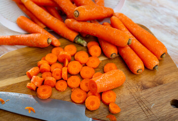 Wall Mural - Many whole and sliced fresh raw carrots on wooden table, food preparation