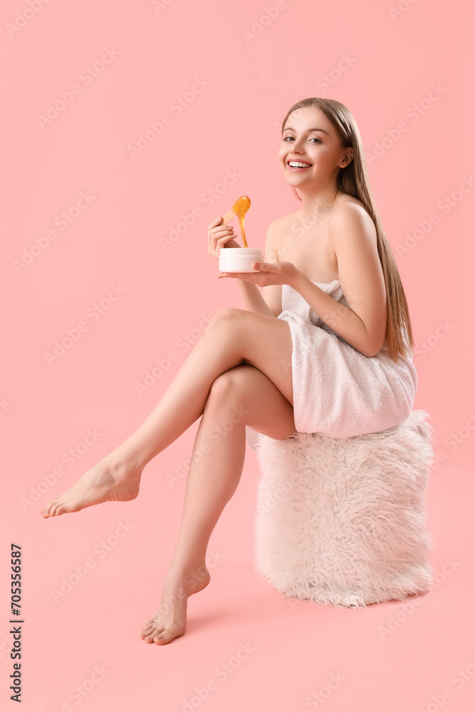Pretty young woman with sugaring paste on pink background