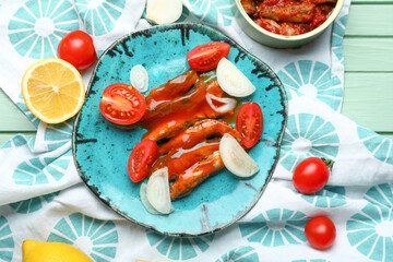 Wall Mural - Composition with canned fish in tomato sauce, lemon and vegetables on green wooden table