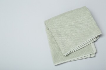 Sticker - Soft green towel on light grey background, top view. Space for text