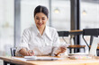 © David - asian woman using calculator and calculate bills in home office. tax form us business income office Financial document. Tax time.Tax concept.