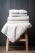 Fluffy white towels piled on a wooden stool  AI generated