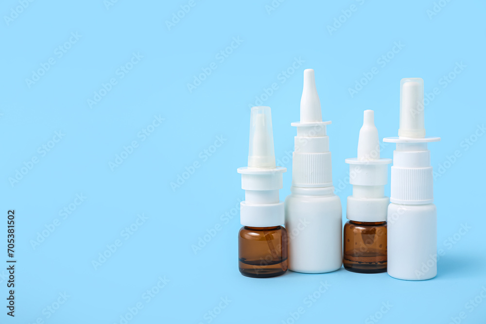 Bottles of nasal drops on blue background