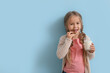 © Pixel-Shot - Cute little girl with glass of tasty milk and cookie on blue background