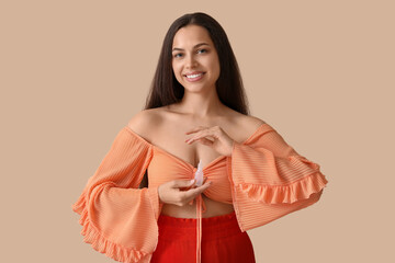 Wall Mural - Young woman with nasal drops on beige background