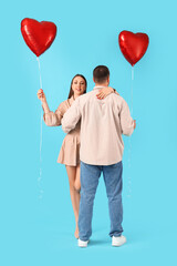 Wall Mural - Lovely couple with heart-shaped balloons on blue background. Valentine's Day celebration