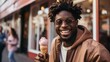 A young African-American man is eating an ice cream cone.