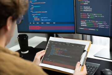 working it developer reading coding on document paper software with screens pc at modern office on c