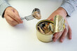 Tin can with ring in male hand. Close up. an empty label for design and text. an employee eats canned fish at work