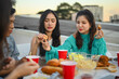 © Prathankarnpap - Young male and female friends enjoying dinner party at rooftop in evening