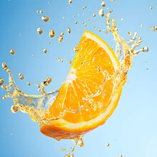 Vibrant Orange Splash With Refreshing Water On Blue Background