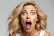 Studio portrait of an attractive young blonde woman with a shocked facial expression.  
