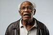 © PixelHarmony - Studio image of an elderly bald African American grandfather wearing glasses and talking towards the camera.
