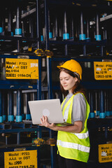 Wall Mural - Female engineer using laptop computer for safety control checks or manufacturing maintenance work in factory building or construction site. woman engineer inspector working in industry product line