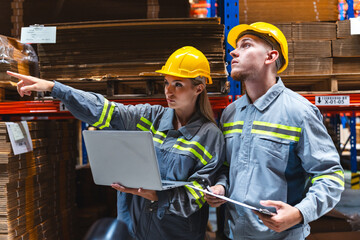 Wall Mural - Engineer wearing safety vest controlling industrial machine working, talking with assistant worker checking first for labour with laptop computer, Officer setting a technology system in factory.