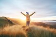 © OMD - person with arms raised on top of a hill at sunrise