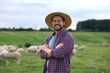 Poster - Portrait of smiling man with crossed arms on pasture at farm