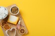 Flat lay composition with natural handmade soap and ingredients on yellow background. Space for text
