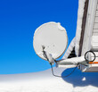 Satellite dish in during snowfall.