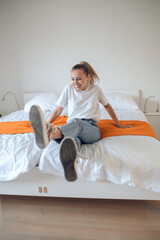 Wall Mural - Young girl in jeans and white tshirt having fun in bedroom