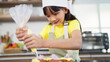 © M Stocker - Little toddler asian girl child in apron and chef hat whipped cream decorating preparing homemade cupcakes in home kitchen. A Little girl preparing and decorating homemade cake. Children cooking