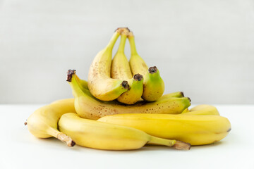 Wall Mural - large pile of ripe delicious yellow bananas on a wooden table on a white background.