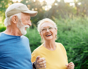 Wall Mural - outdoor senior fitness woman man lifestyle active sport exercise healthy fit couple running jogging elderly mature having fun laughing talking together friend hug break