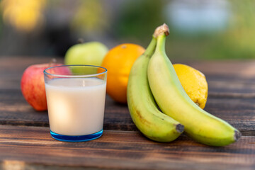 Wall Mural - Multifruit juice and fresh fruit on table on kitchen background closeup