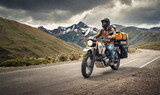 Fototapeta  - Adventurous motorcycle rider on the road on a motorcycle with camping bags