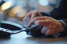 A close-up view of a person using a mouse. This image can be used to illustrate computer usage or technology concepts