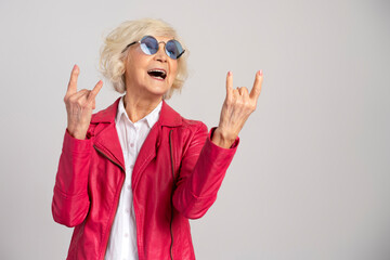 Canvas Print - Grey hair excited caucasian woman wearing glasses showing rock gesture