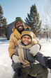 © pressmaster - Happy young African American man and his cute son in warm winterwear taking selfie and looking at camera on winter weekend