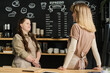© pressmaster - Young waitress with Down syndrome looking at her colleague during discussion of working points while standing by counter