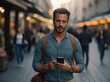 © SKOPUS DRON - Handsome bearded young man on his 30s, looking at camera while strolling through the street with his mobile phone in his hand. Casual businessman.