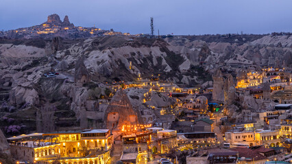 Wall Mural - Goreme City at twilight, Famous tourist center of balloon fligths in Cappadocia, Turkiye, Aerial view twilight Goreme City from the mountain, Night view of Goreme, Cappadocia, Turkey.