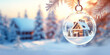A house model in a transparent keychain ball hangs on a Christmas tree branch against the backdrop of a winter forest on a sunny day. Decorative keychain. Concept of buying a house, real estate, land