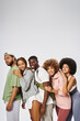 © LIGHTFIELD STUDIOS - group of positive young african american friends standing together on grey background, community