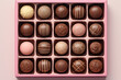 Assortment of luxury bonbons in box on pastel pink background. Exclusive handmade chocolate candy. Minimal food concept
