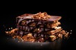  a stack of chocolate covered bars sitting on top of a black table next to a pile of nuts and granola on top of each of each of the bars.