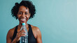 Happy mature black african american woman in fitness clothing holding a bottle of water, active senior black woman
