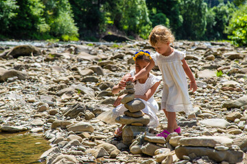 Poster - Children throw stones into the river. Selective focus.