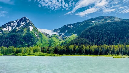 Wall Mural - Eternal snow on Girdwood Glacier in Alaska USA under clear blue Sky and in front a grey blue lake - landscape shot taken on the water from a boat: concept of summertime, travel, outdoor