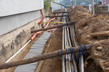 Wall Mural - Construction work. Line of old and new cables buried underground on the street. underground electric cable infrastructure installation. Construction site with A lot of communication Cables