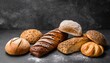 assortment of fresh baked bread on dark background white and rye bread buns with copy place
