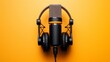 The dynamic duo of professional podcasting, a microphone and headphones, set against a yellow backdrop, perfect for high-quality audio recording and music production.