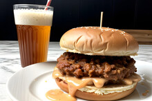 A delicious-looking image depicting a pulled-pork sandwich and beer