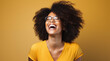Jeune femme noire, heureuse, souriante, avec des lunettes, arrière-plan jaune