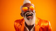 Homme noir senior, souriant, heureux avec barbe et lunettes, arrière-plan orange