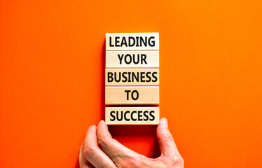 Wall Mural - Leading your business to success symbol. Concept words Leading your business to success on wooden blocks. Beautiful orange table orange background. Leading your business to success concept. Copy space