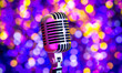 © tiero - vintage microphone with blurred coloured lights in the background.